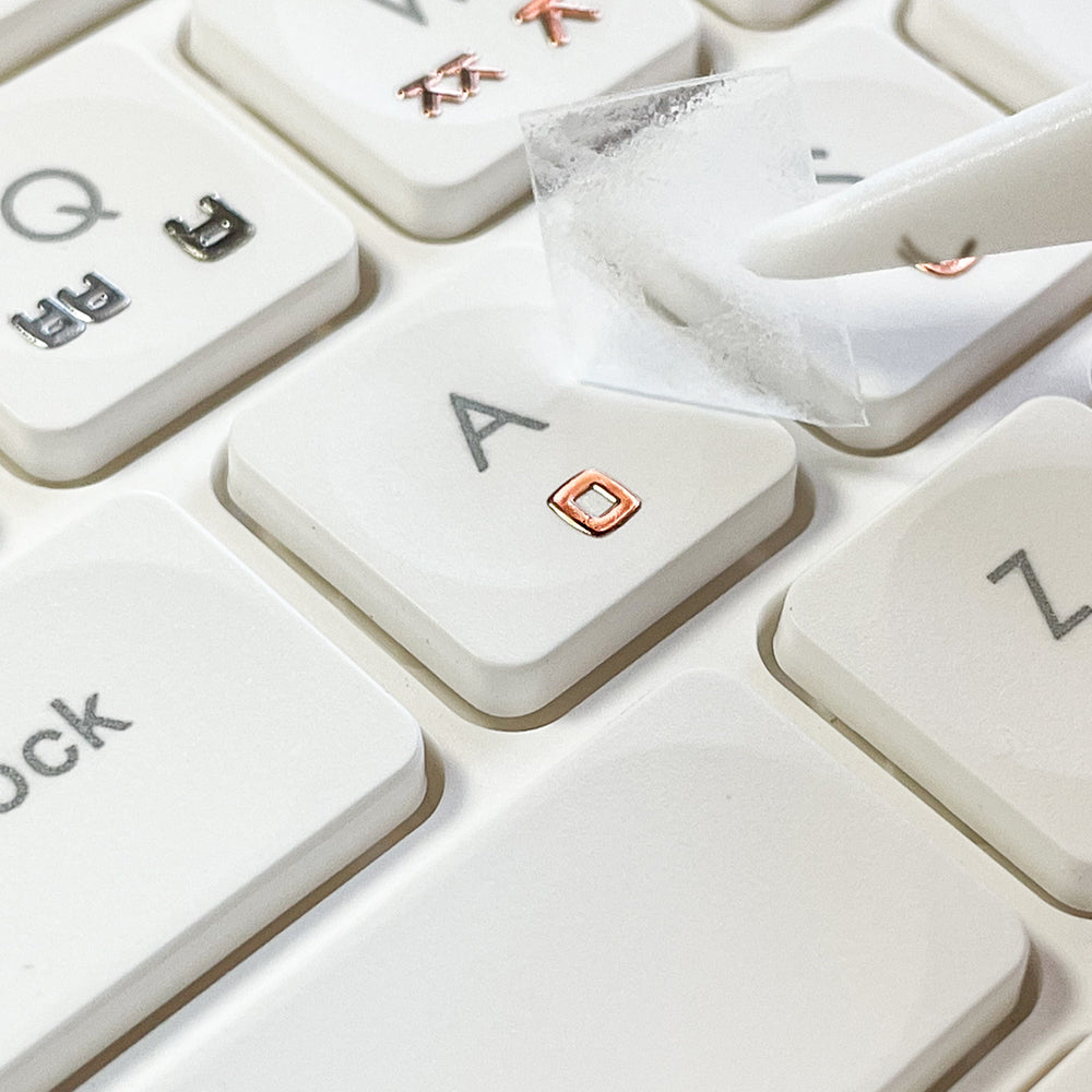 Close-up of a keyboard with Korean keyboard stickers applied to the keys, showing a seamless sticker die cut design placed on keyboard. Color of keyboard sticker Rose Gold.