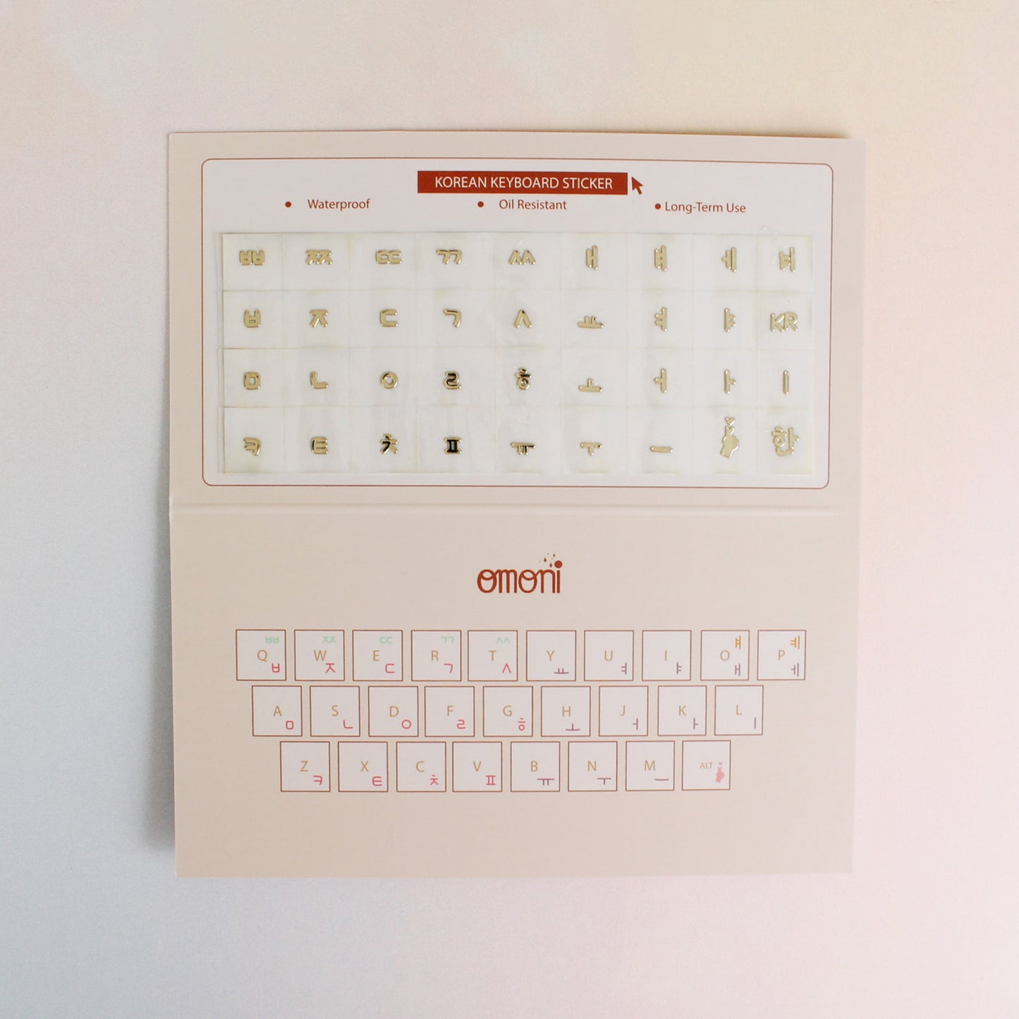 An image showing a laptop keyboard packaging with Korean seamless sticker set. Seamless die-cut Korean Hangul keyboard sticker with Korean alphabet letters for learning Korean, typing practice, vocabulary building and beginner Korean language lessons. Metallic gold.