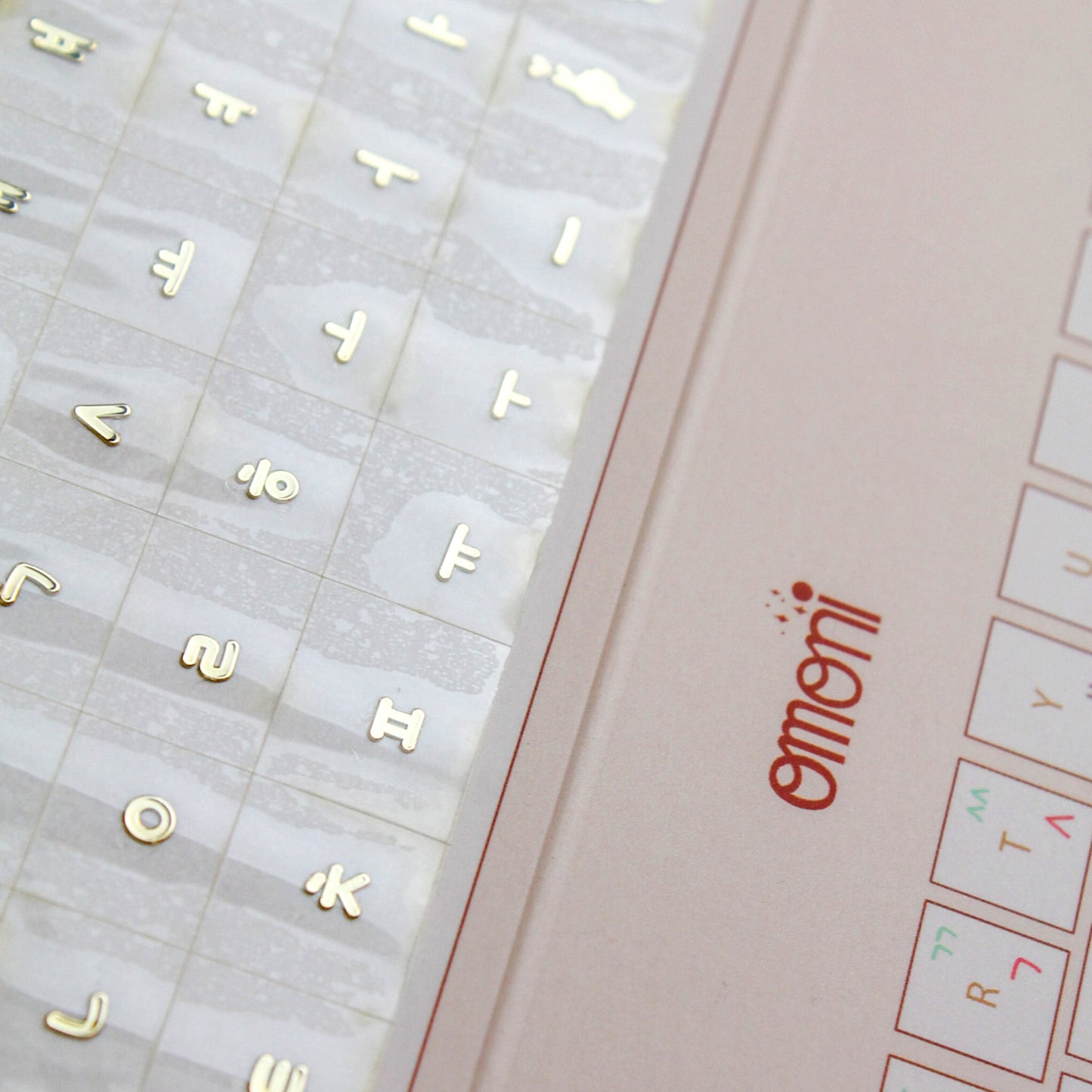 A zoomed image showing a laptop keyboard packaging showcasing the Korean seamless die-cut sticker set. Seamless die-cut Korean Hangul keyboard sticker with Korean alphabet letters for learning Korean, typing practice, vocabulary building and beginner Korean language lessons. Keyboard Sticker Metallic Gold Color in a super zoomed photo.